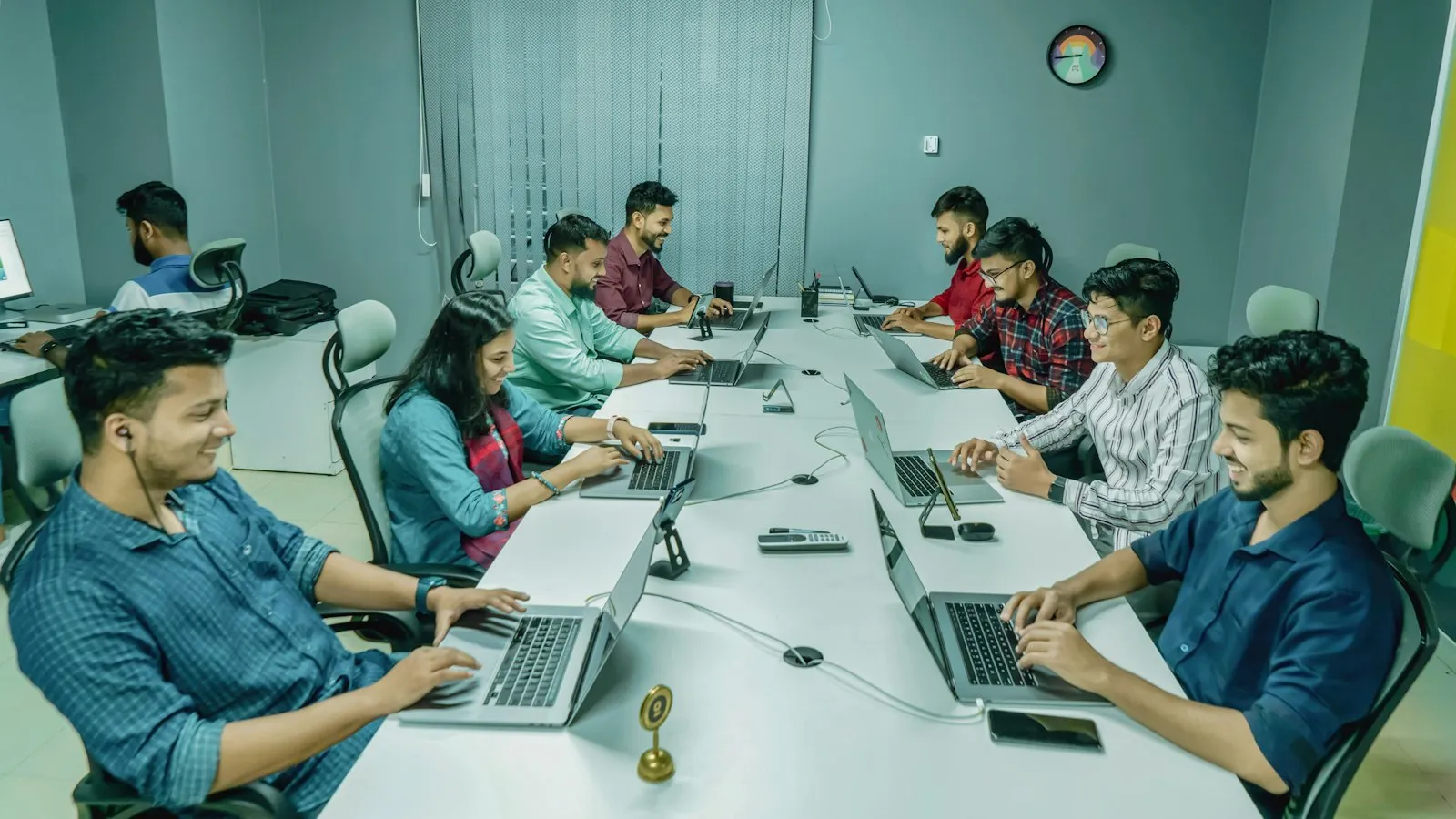 Software development team working on laptops in an office